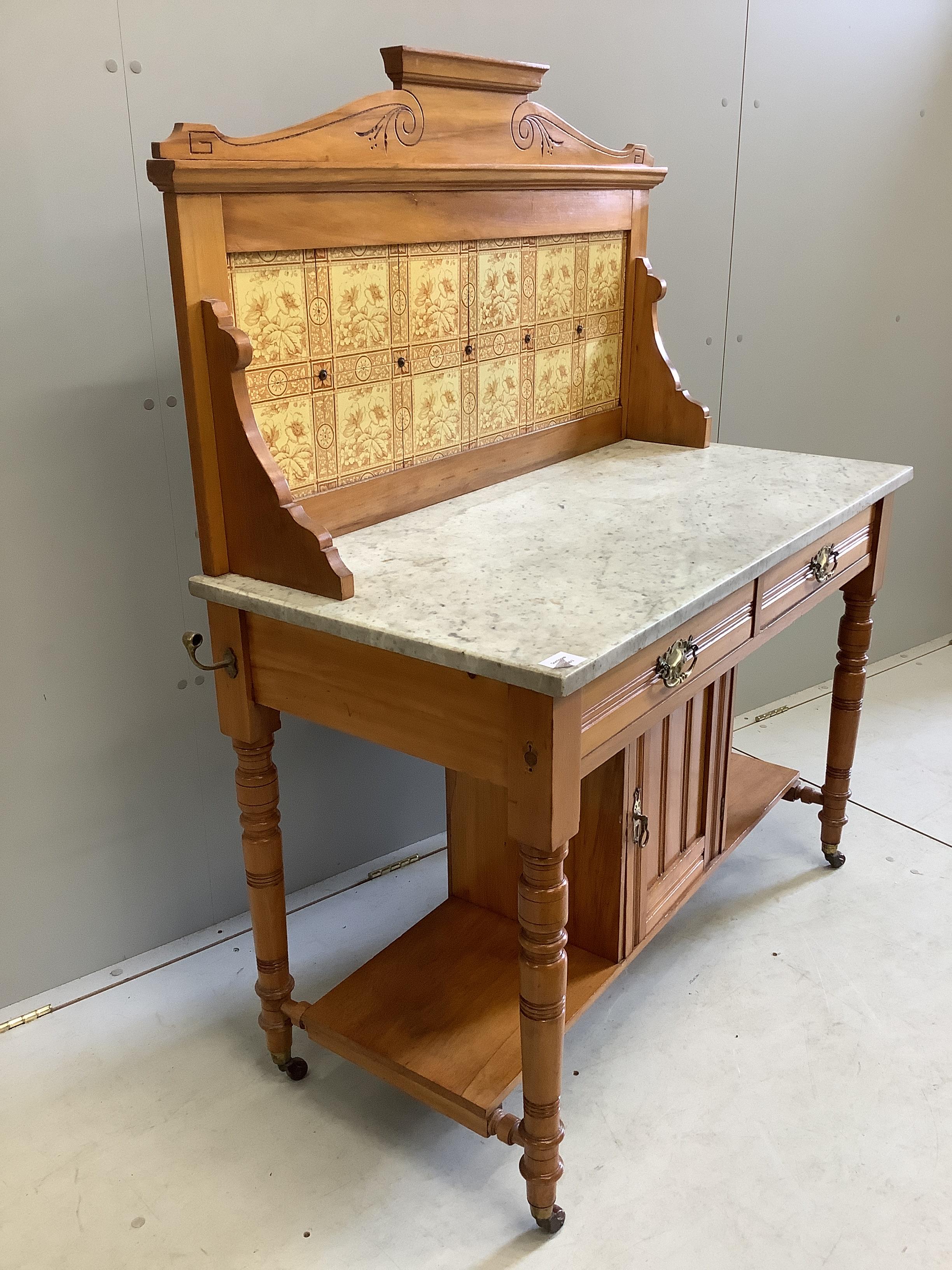 A late Victorian satin walnut tiled back marble top washstand, width 106cm, depth 52cm, height 133cm